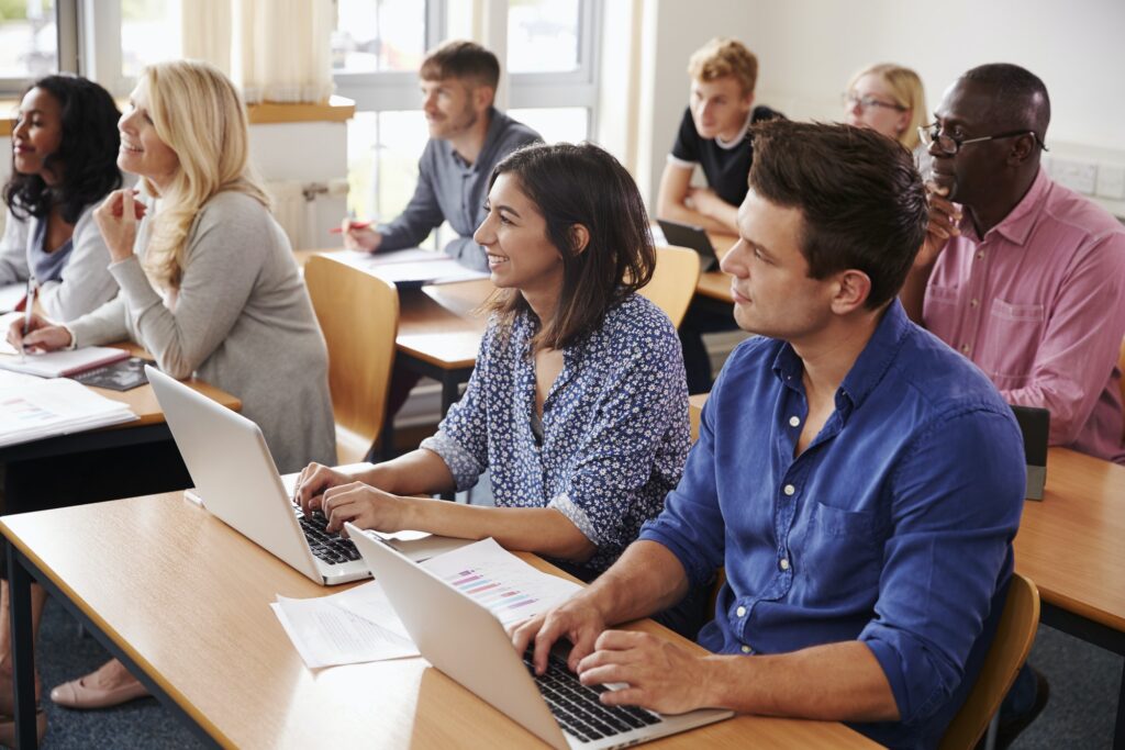 Mature Students Sitting At Desks In Adult Education Class