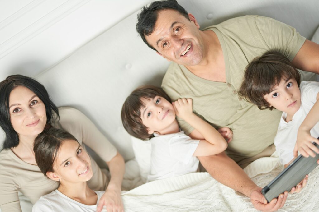 Together at home. Portrait of happy latin famile, little kids and parents smiling at camera while